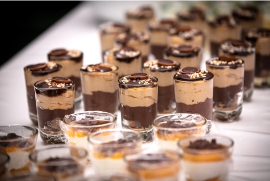 Mini chocolate mousse desserts in small glasses on a Easter high tea buffet table.