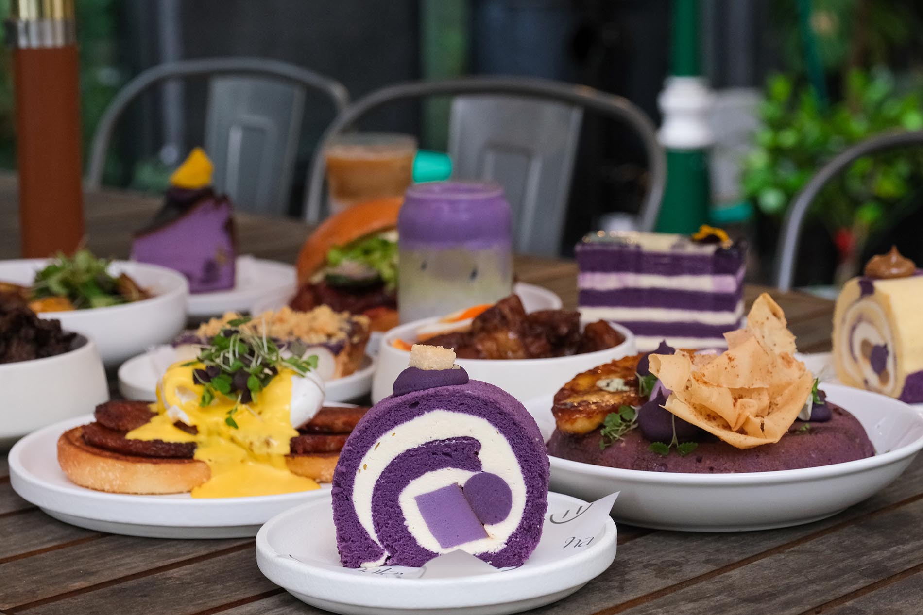 A spread Filipino brunch dishes with an ube swiss roll at the front.
