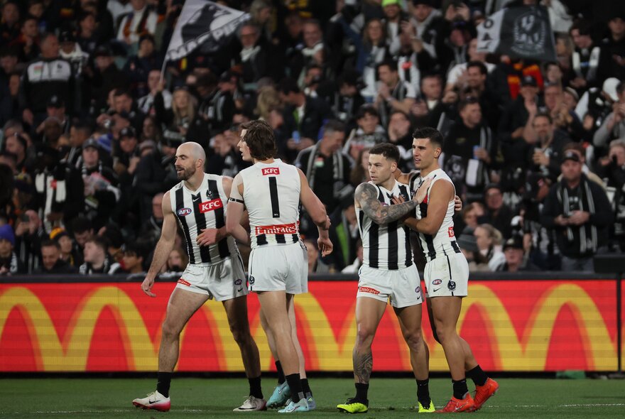 Collingwood AFL football players on the field during a match.