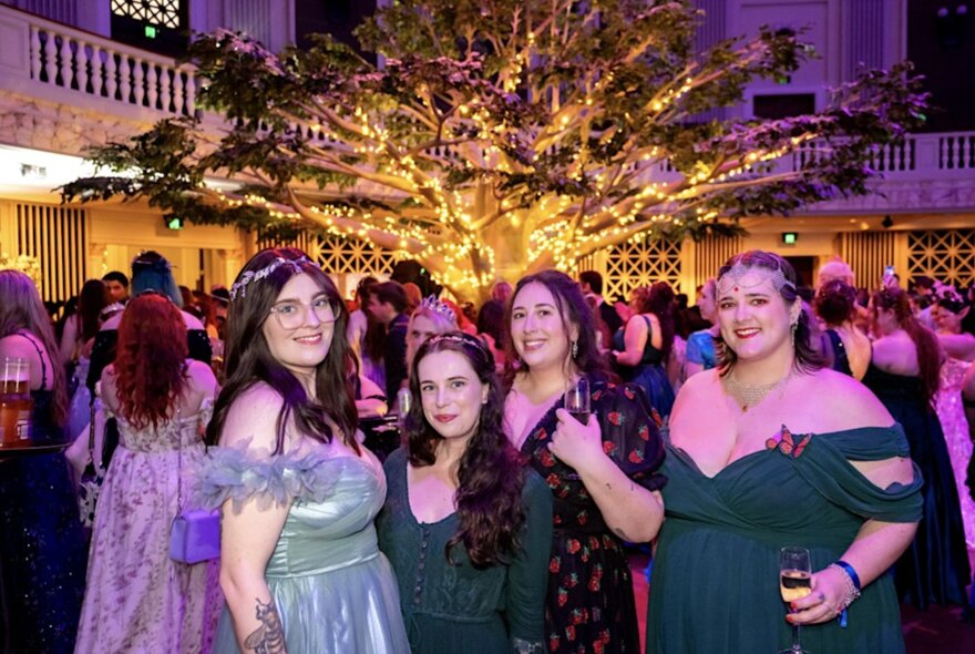 A group of young women wearing off-the-shoulder gowns in a formal setting.