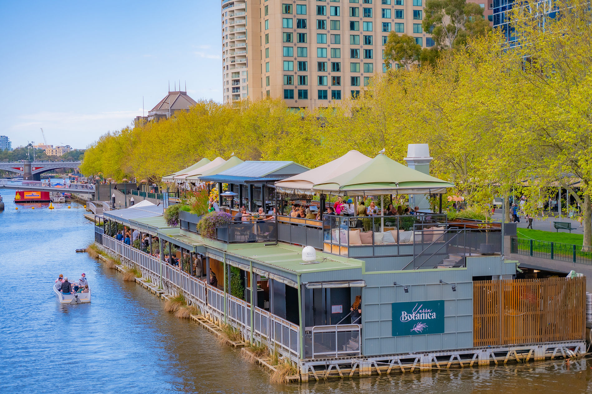 A multi-level floating bar on the river on a nice day.