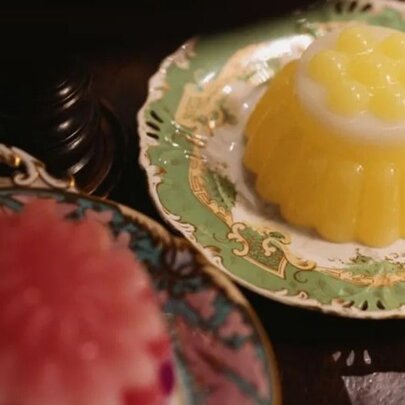 Red and yellow moulded desserts on antique plates.