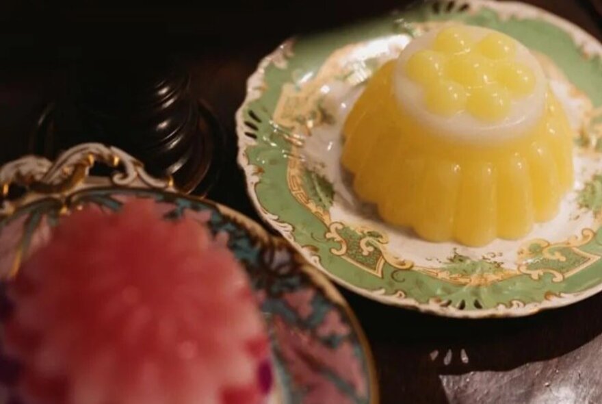 Red and yellow moulded desserts on antique plates.