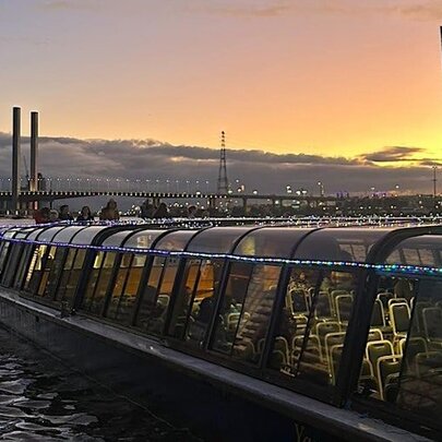A sightseeing boat on the harbour against a twilight background.
