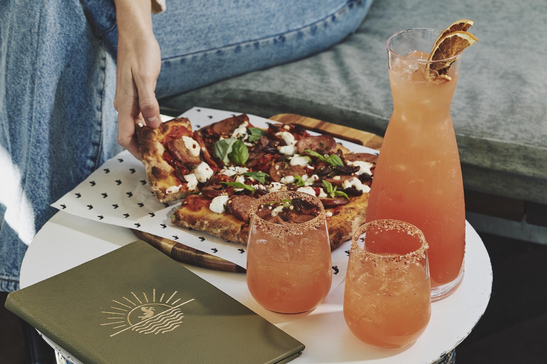 A pizza and carafe of cocktails.