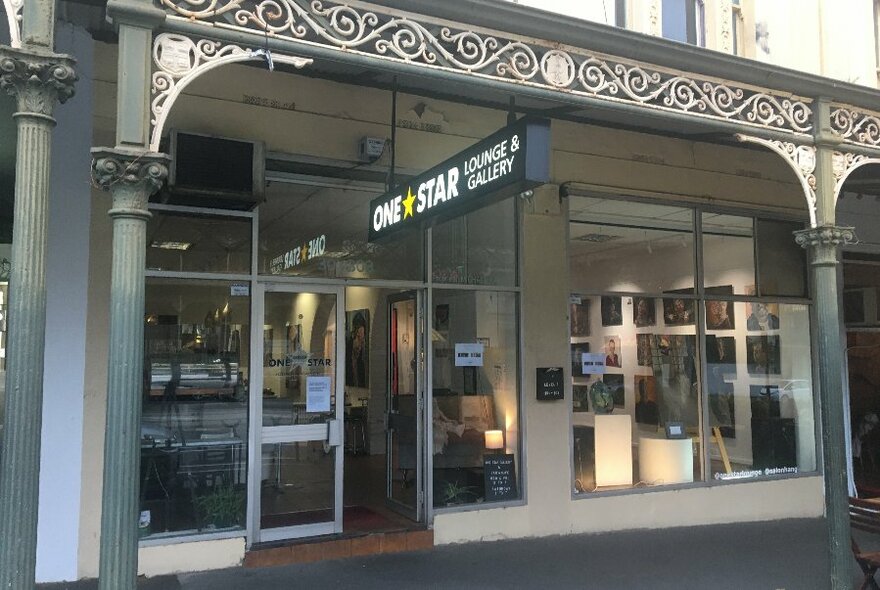 The exterior of a cafe with a Victorian verandah. 