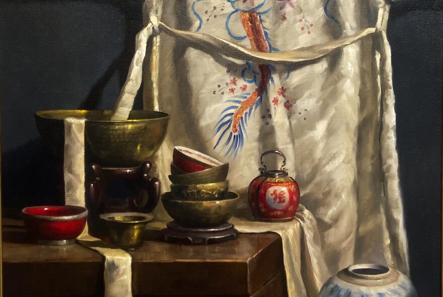 Still life painting of Asian bowls next to a silk embroidered curtain.