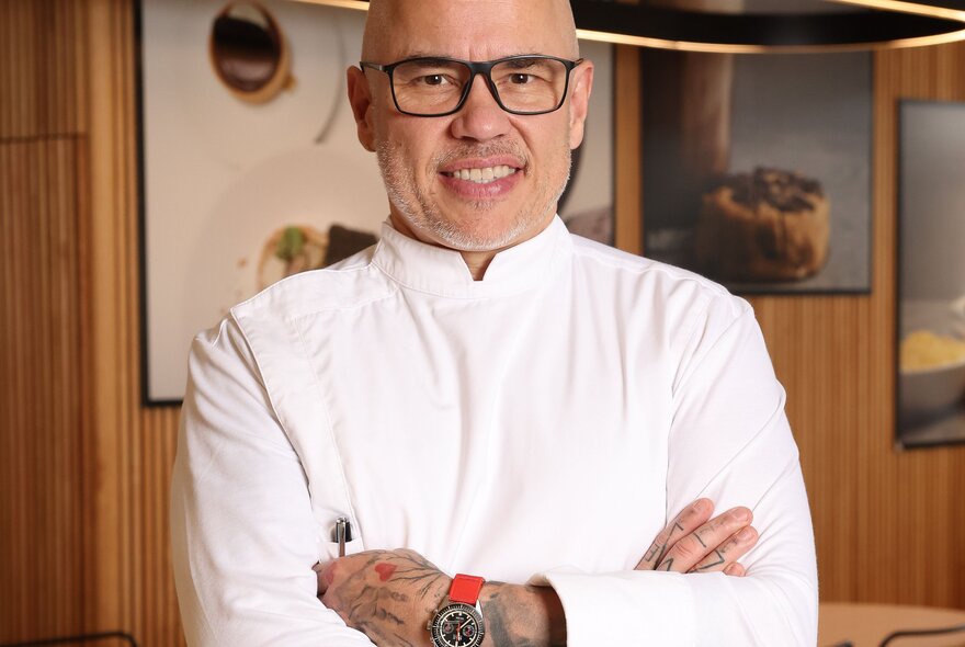 Chef Pierrick Boyer smiling with arms crossed in a restaurant. 