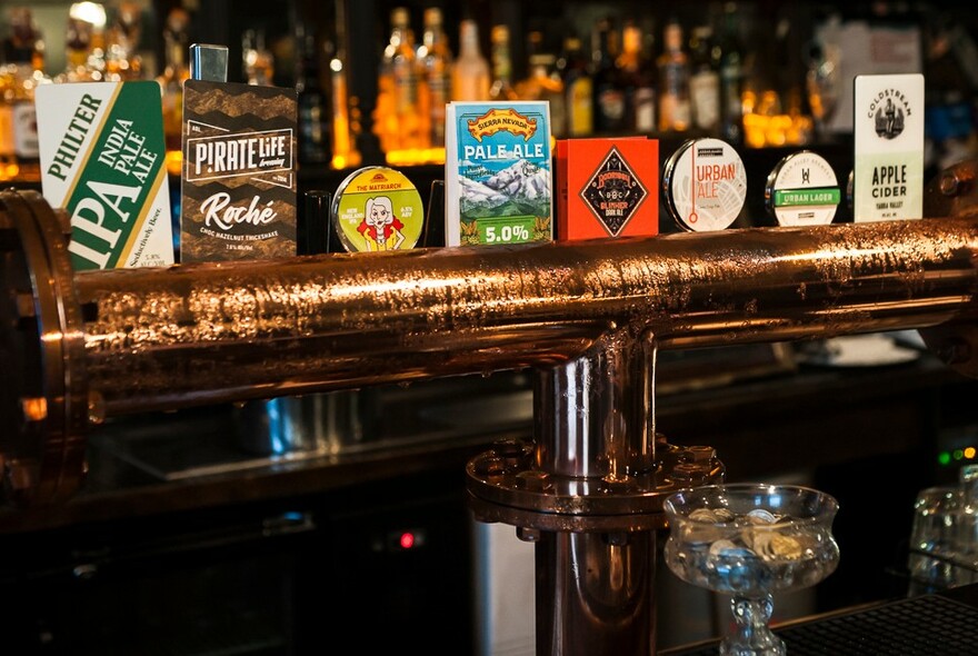 Pub counter with beer on tap signs, bottles and glasses.