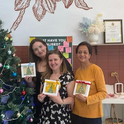 Group of people holding up chocolate painting.