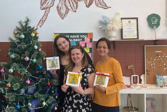 Group of people holding up chocolate painting.