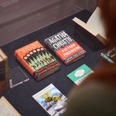 Looking over a blurred shoulder at a table with books displayed. 