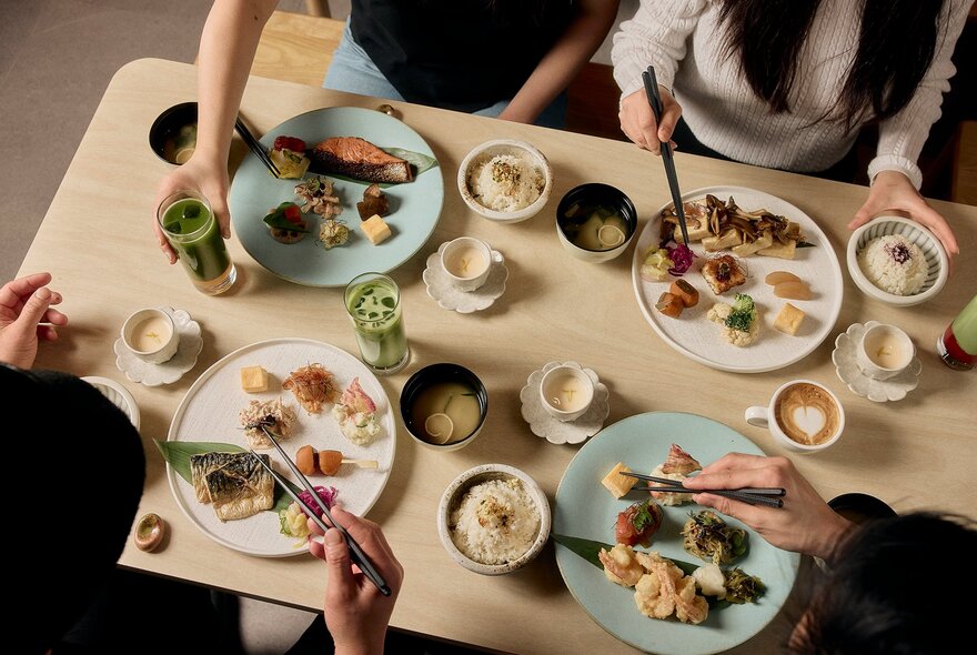 People dining on Japanese food with beautifully presented bite sized dishes, coffee and matcha.