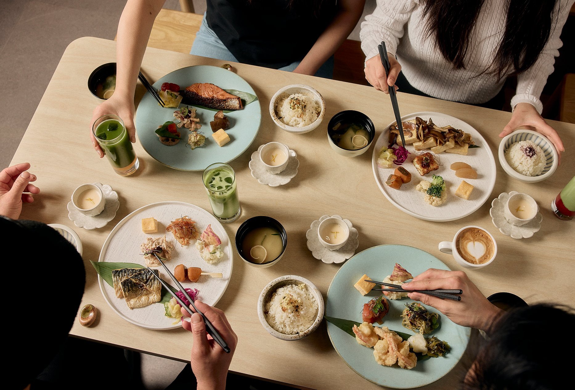 People dining on Japanese food with beautifully presented bite sized dishes, coffee and matcha.