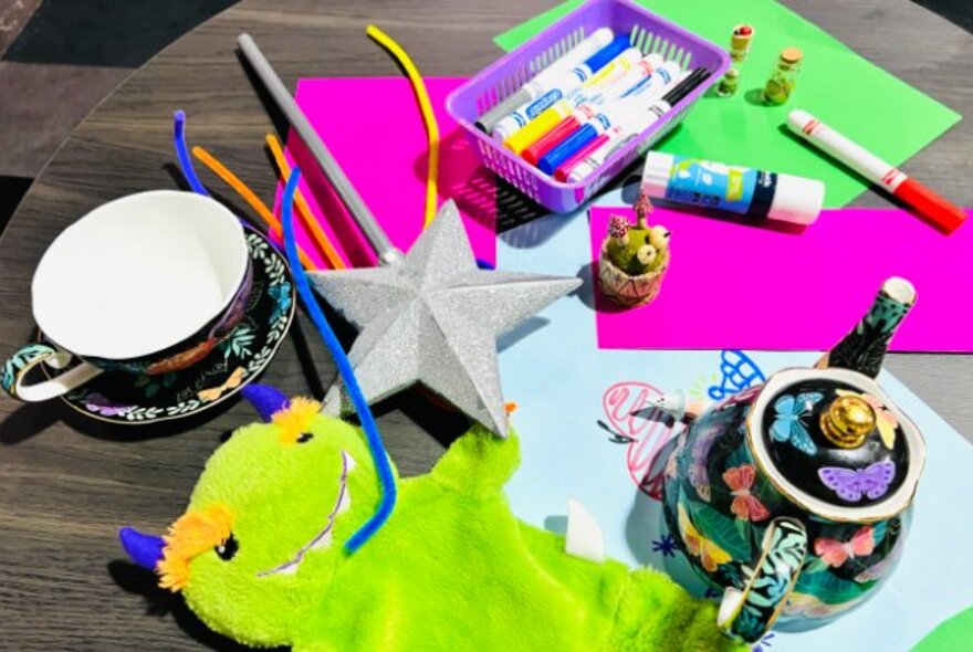 Kids craft materials including green puppet and tea set.