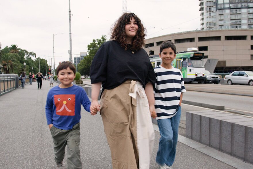 Julia and her two kids walking across Princes Bridge
