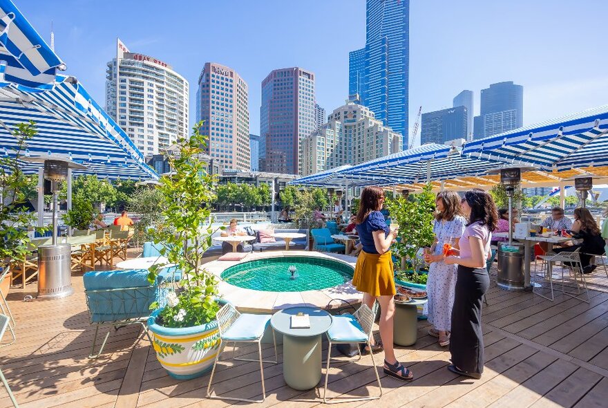 A group of friends are drinking at a rooftop bar.