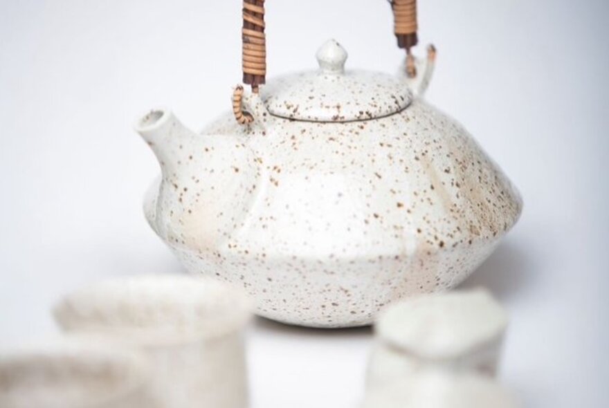 A ceramic tea pot and matching cups at a Japanese market stall.