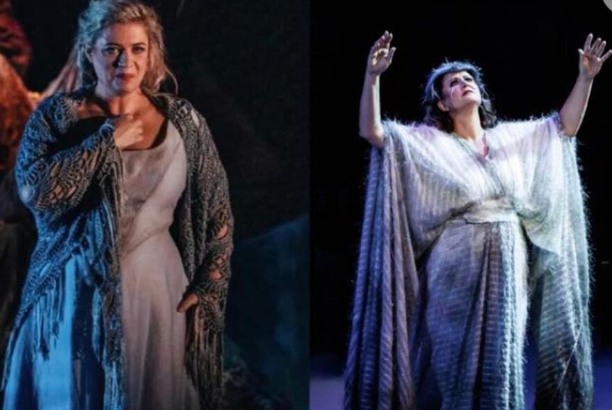 Two opera singers in costume on stage, one wearing a shawl and grey dress, the other with arms and head raised to the sky wearing a woollen robe.