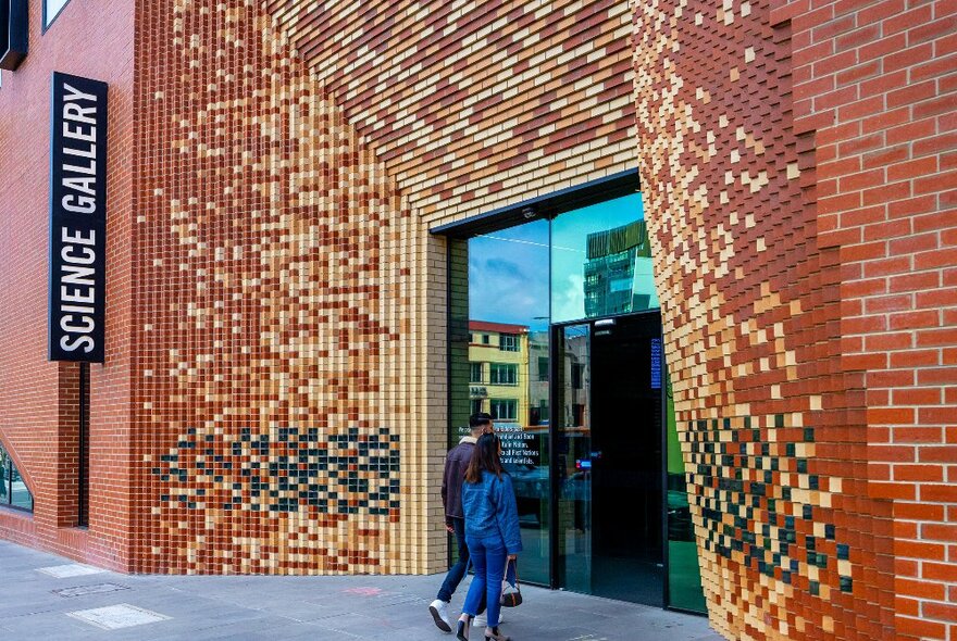 Two people are walking into a Science Gallery