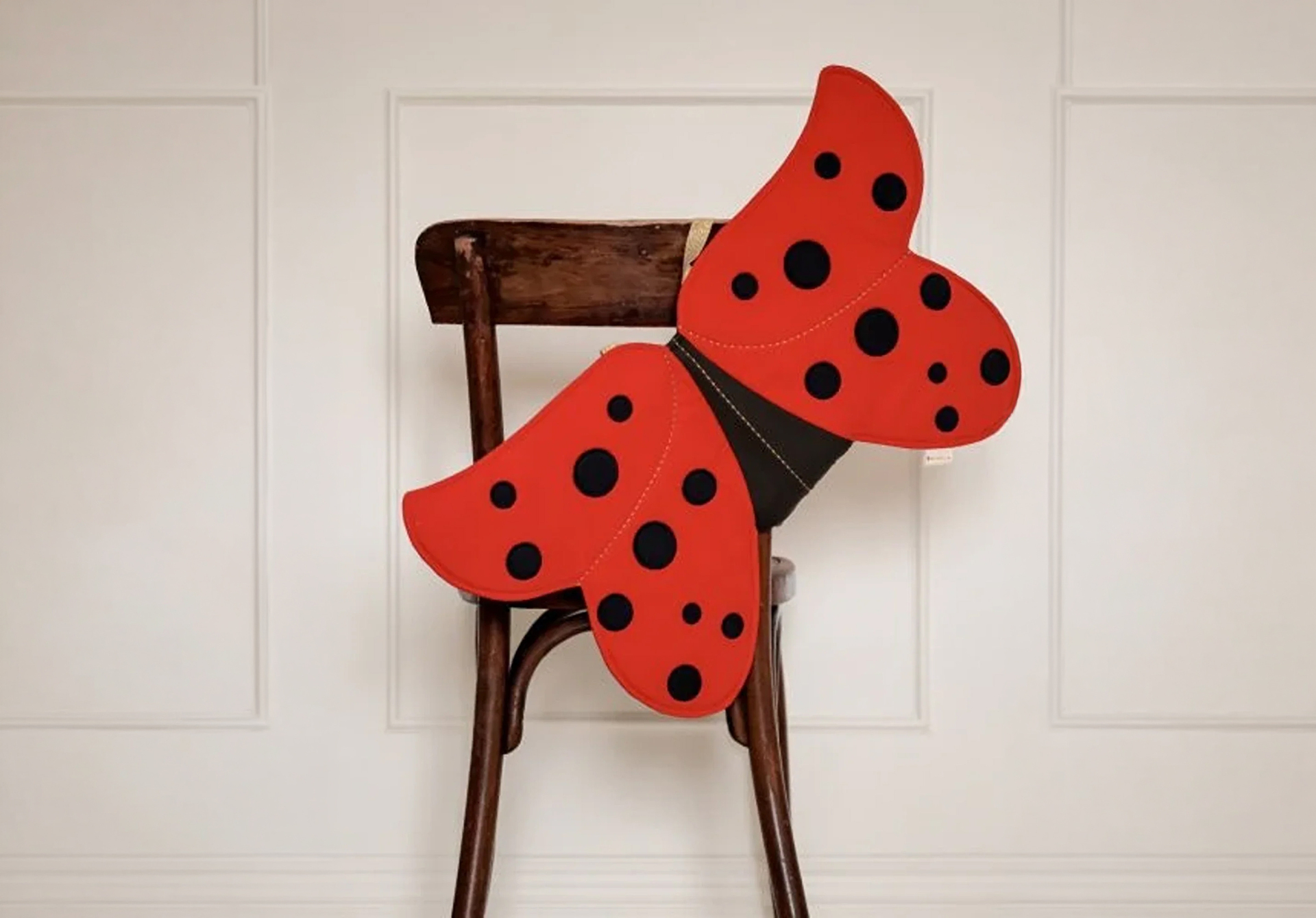 A pair of ladybug wings costume hanging on a chair. 