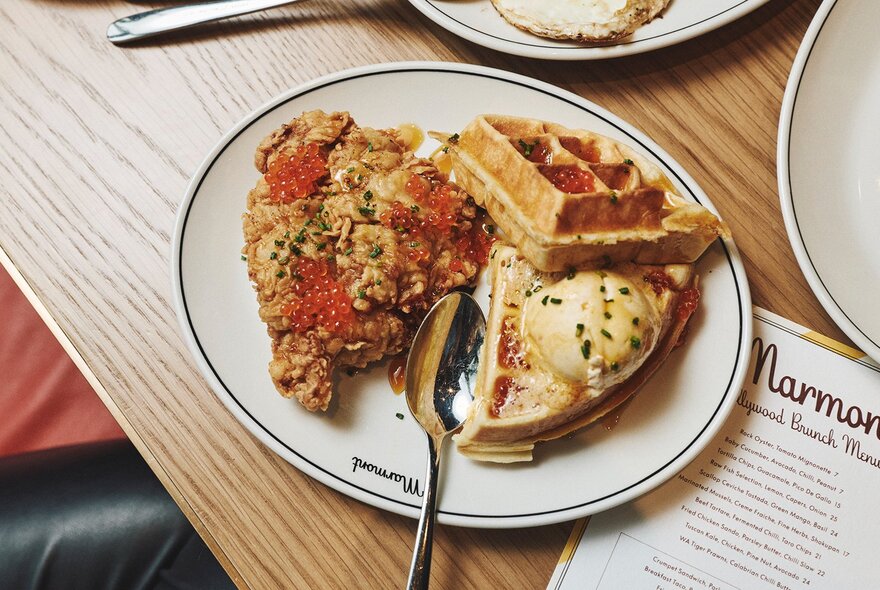 Fried chicken and waffles with caviar on a restaurant table. 