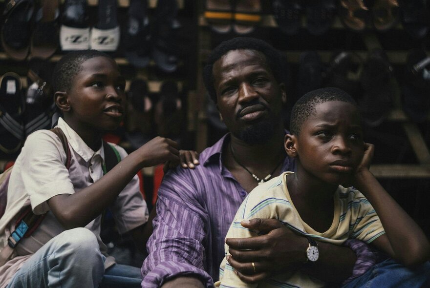 A still from a film showing a Nigerian father and his two children.