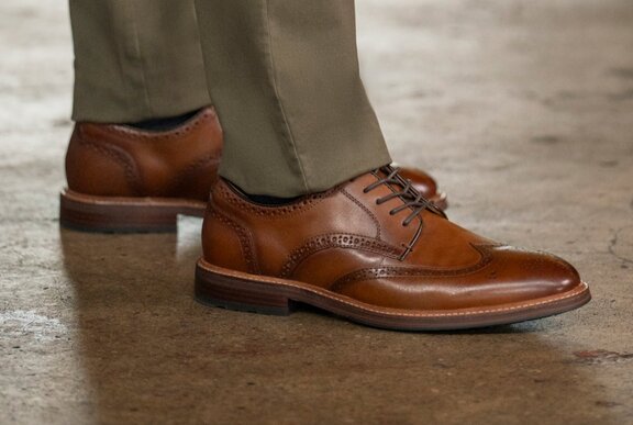 Brown leather brogues on the end of khaki trousers.