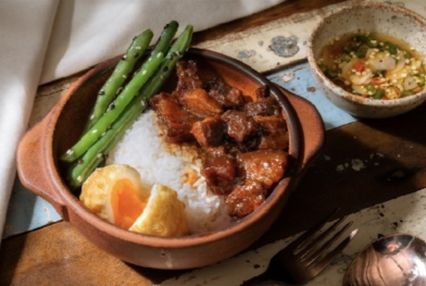 A bowl of rice with egg and asparagus.