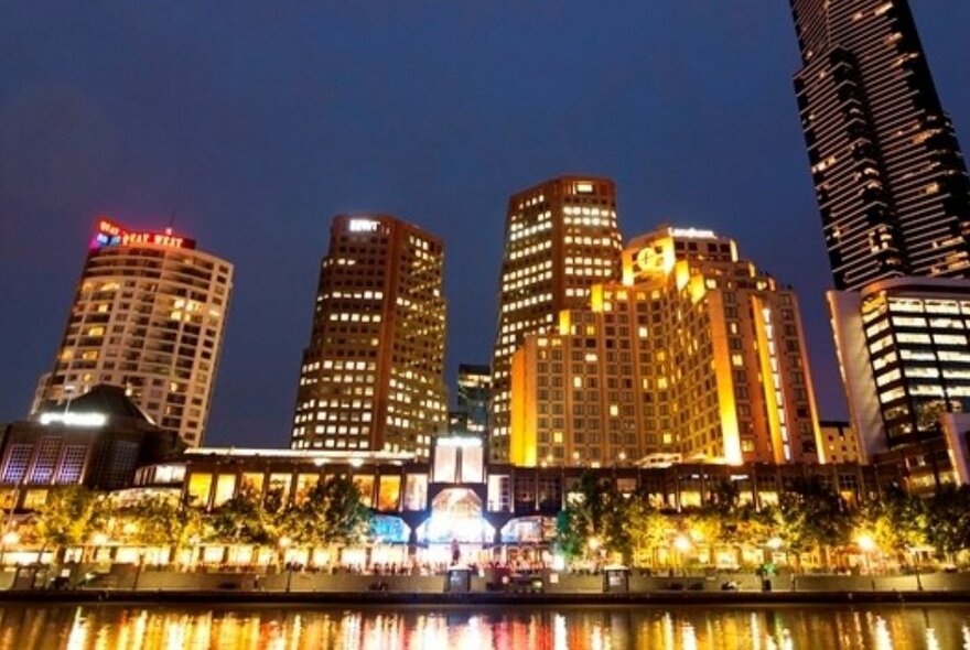 Looking south towards the Southgate precinct and promenade across the Yarra River, the  buildings with their lights on brightening up the night sky.