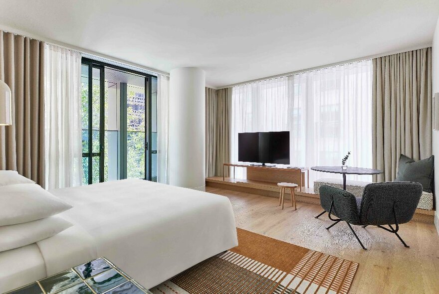 Internal view of a hotel room at the Hyatt Centric Hotel Melbourne featuring a queen size beed and large windows.