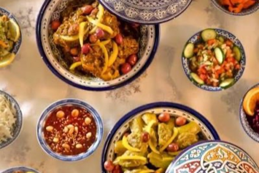 An array of Moroccan dishes in colourfully painted clay bowls.
