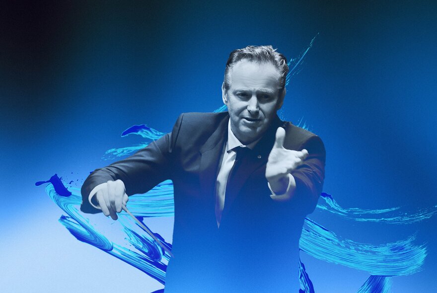 An orchestra conductor with his left arm outstretched in front of him, and holding a baton in his right hand; a swirl of blue as the background.
