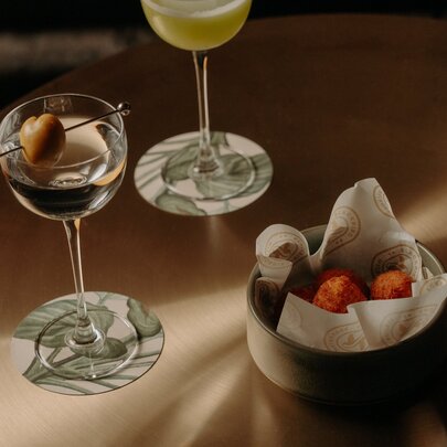Two cocktails and a small snack bowl.