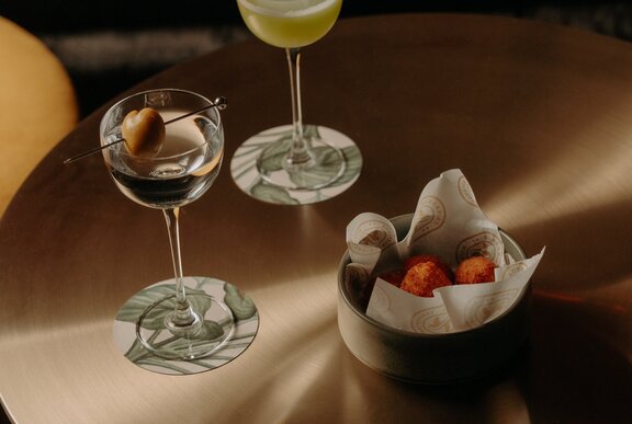 Two cocktails and a small snack bowl.