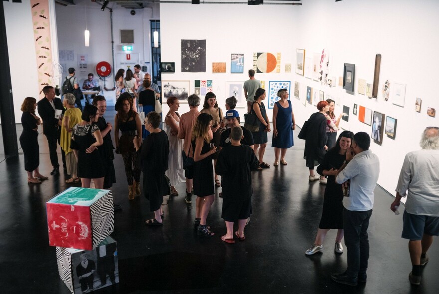 People gathered inside a gallery.