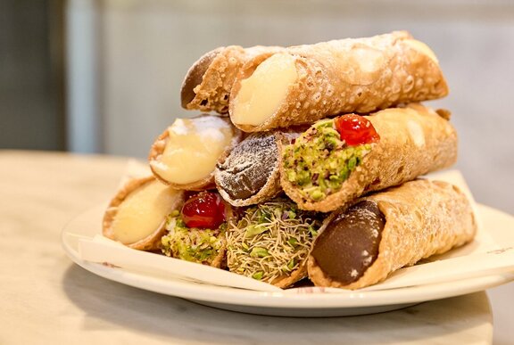 A stack of cannoli with different flavoured fillings.