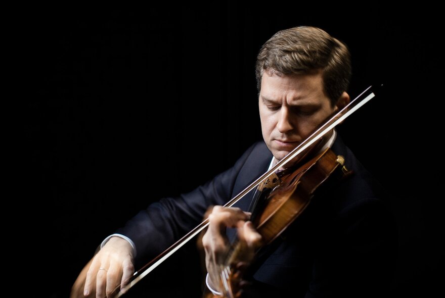Master violinist James Ehnes playing against a black background. 