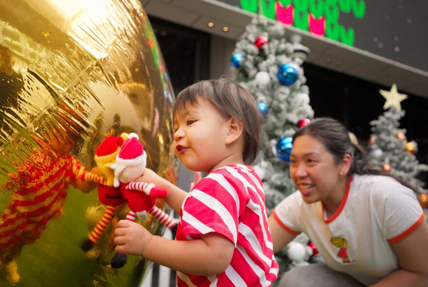 Child and adult with toys and Christmas decorations.
