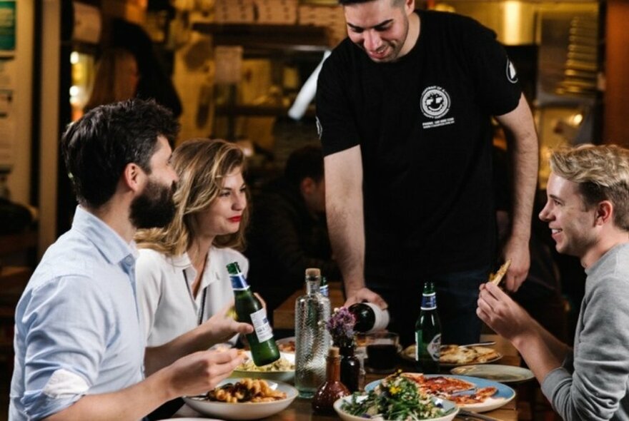 Staff serving wine to diners.