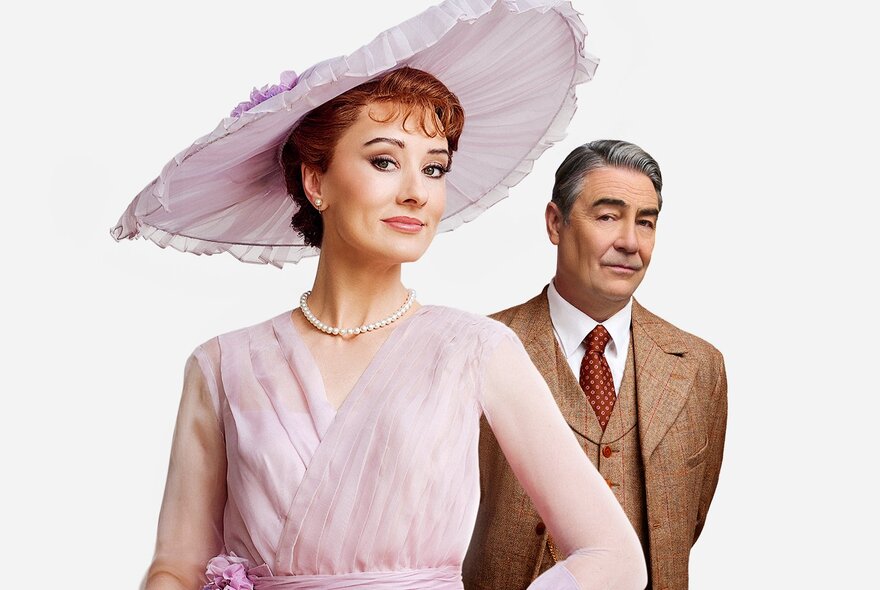 A scene from the musical My Fair Lady with Eliza Doolittle in a pink dress and hat and Henry Higgins in a tweed three-piece suit. 