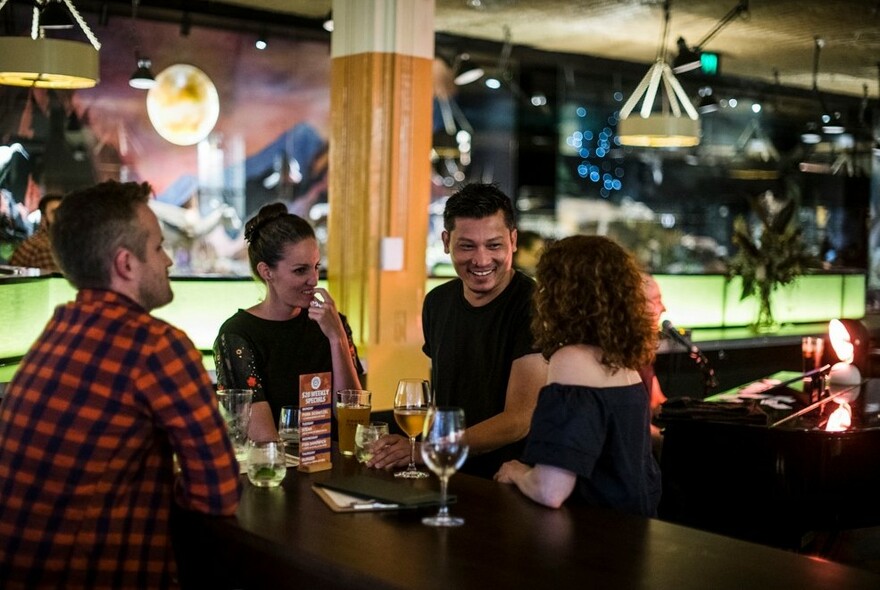 A group of people laughing and drinking.