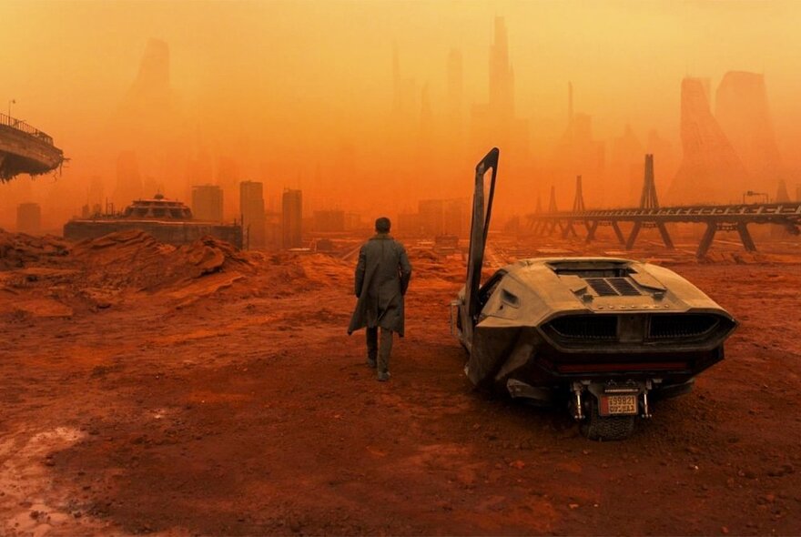 A scene from a movie showing a red-tinged futuristic world, the air thick with pollution, and a solitary figure standing near a cyber vehicle. 