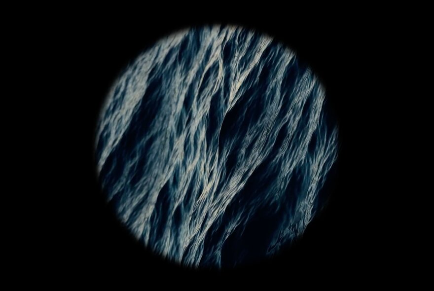 Black background with a circle inset of ripples on dark water.
