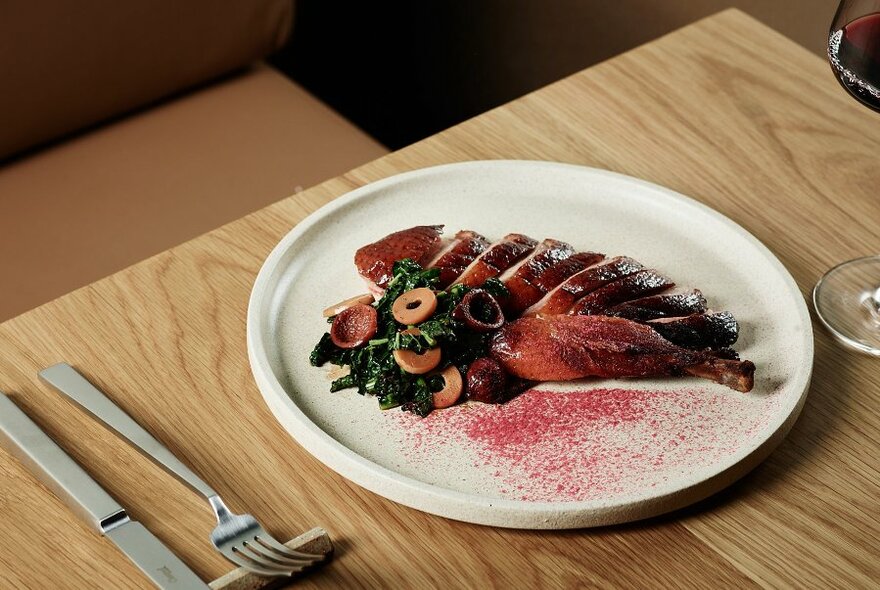 Roasted sliced duck artfully arranged on a plate.