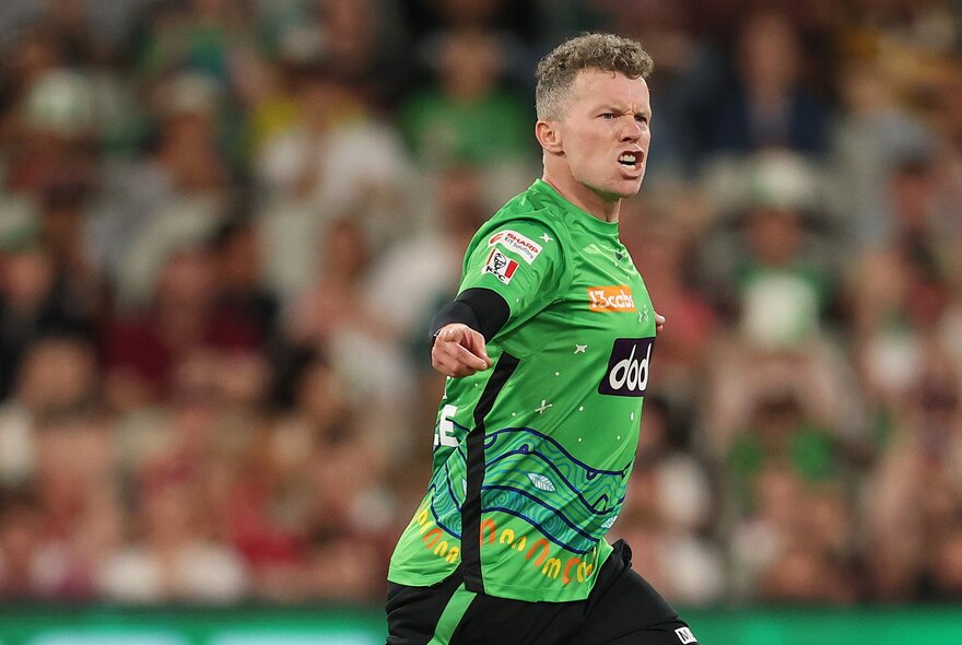 A Melbourne Stars player pointing and speaking with a blurred crowd in the background. 
