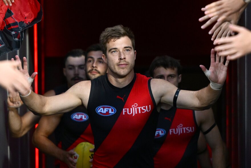 Essendon AFL football players leaving the grounds and interacting with their fans.