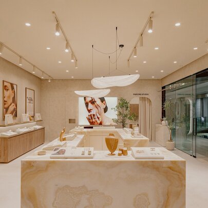 Interior of a high-end jewellery store with marble benches and lights on strip brackets.