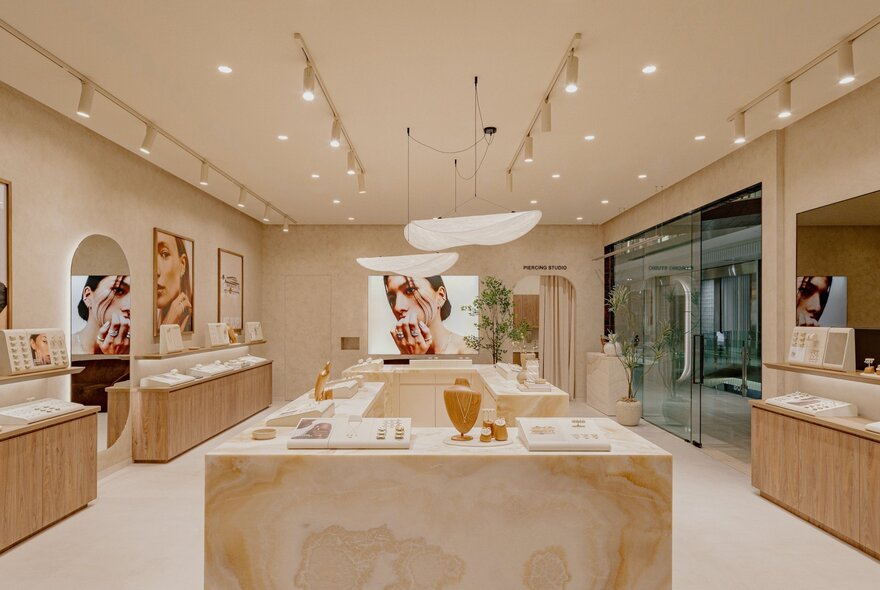 Interior of a high-end jewellery store with marble benches and lights on strip brackets.