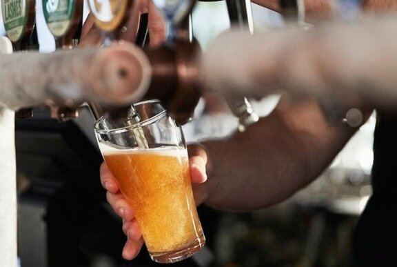 Glass of beer being poured from a tap in a bar.